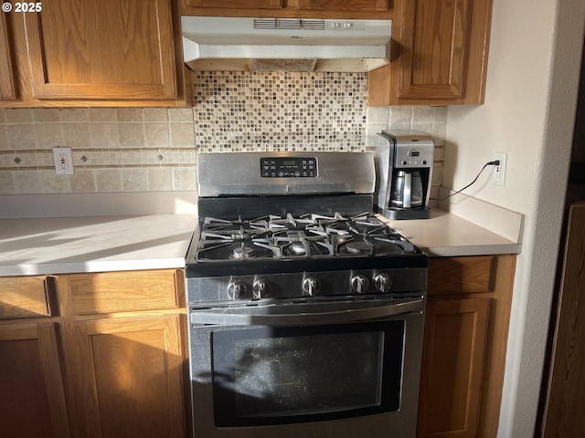 kitchen with stainless steel gas range oven and backsplash