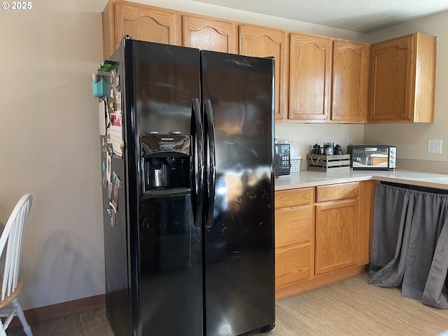 kitchen with black fridge and light hardwood / wood-style floors