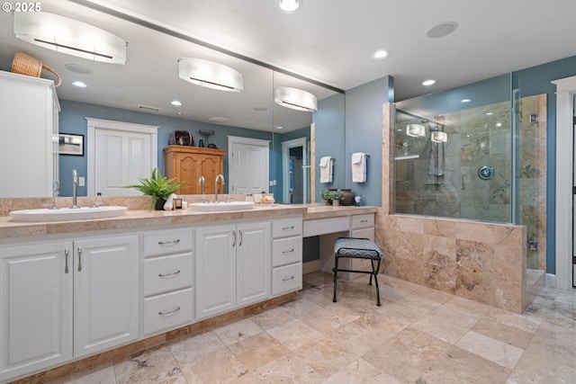 full bath with double vanity, recessed lighting, a stall shower, and a sink