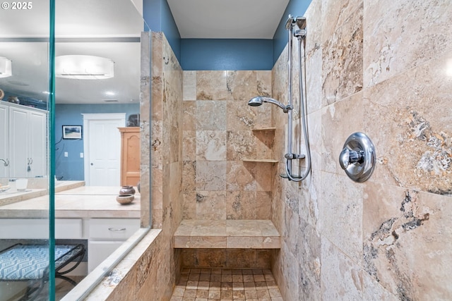 bathroom with tiled shower and vanity