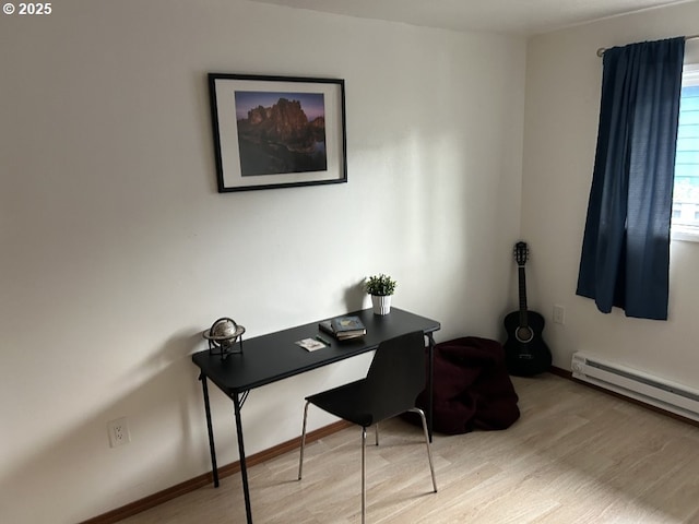 office with wood finished floors, a baseboard heating unit, and baseboards