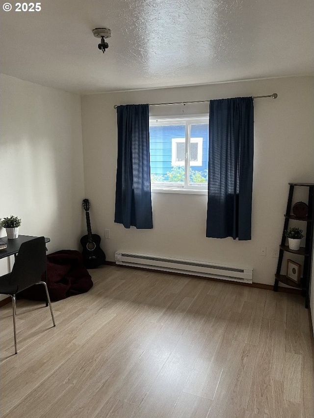 spare room with a baseboard radiator and wood finished floors