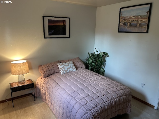 bedroom with wood finished floors and baseboards