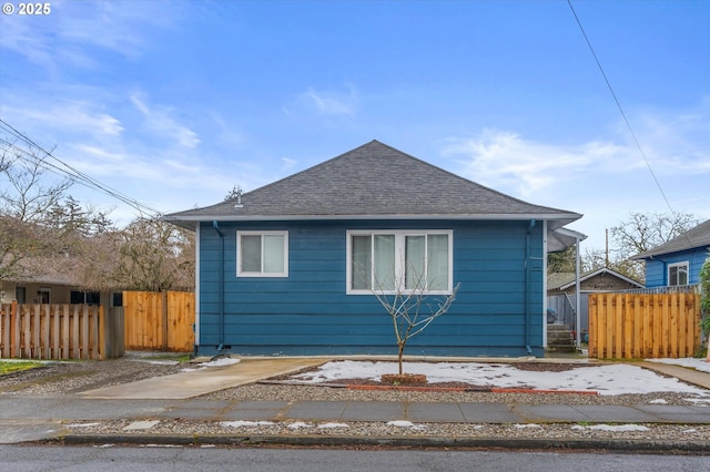 view of front of home featuring fence and roof with shingles