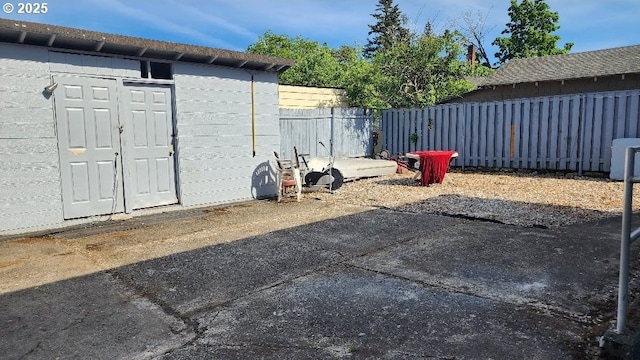 view of yard featuring fence, an outdoor structure, and a shed