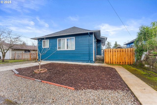 view of front of home featuring fence and a shingled roof