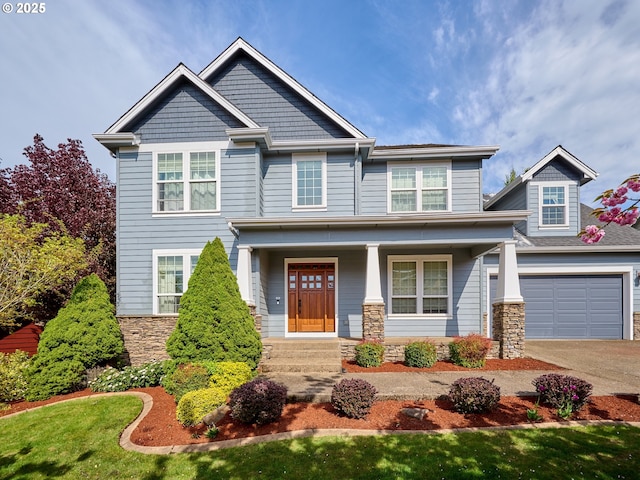 craftsman house featuring stone siding, a porch, and driveway