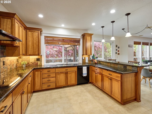 kitchen featuring a peninsula, a kitchen bar, a sink, brown cabinetry, and black appliances