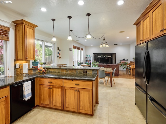 kitchen featuring a peninsula, brown cabinets, black appliances, and recessed lighting