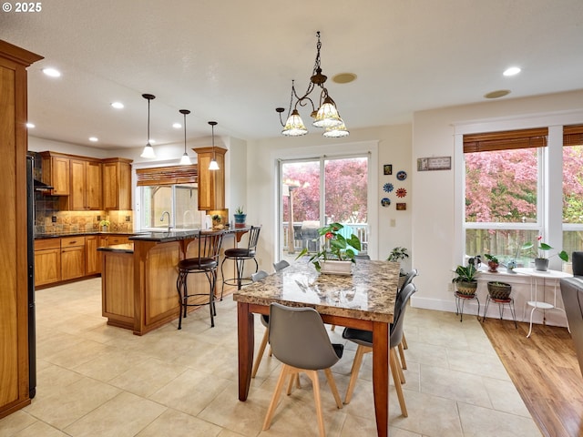 dining area featuring a notable chandelier, plenty of natural light, light tile patterned floors, and recessed lighting