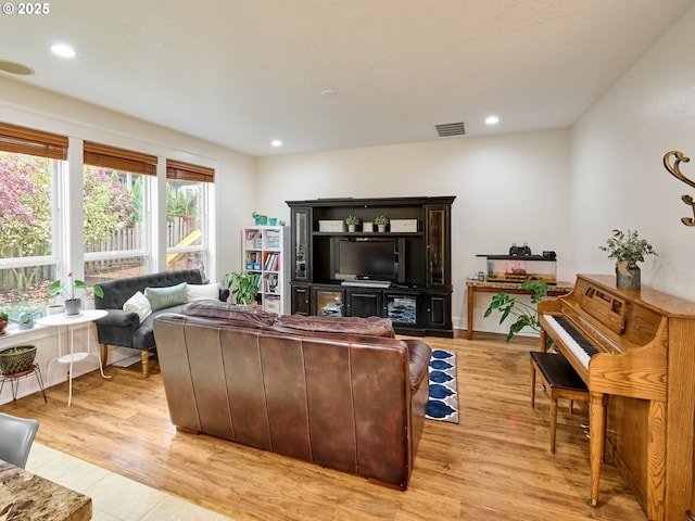 living room featuring light wood-style floors, visible vents, and recessed lighting