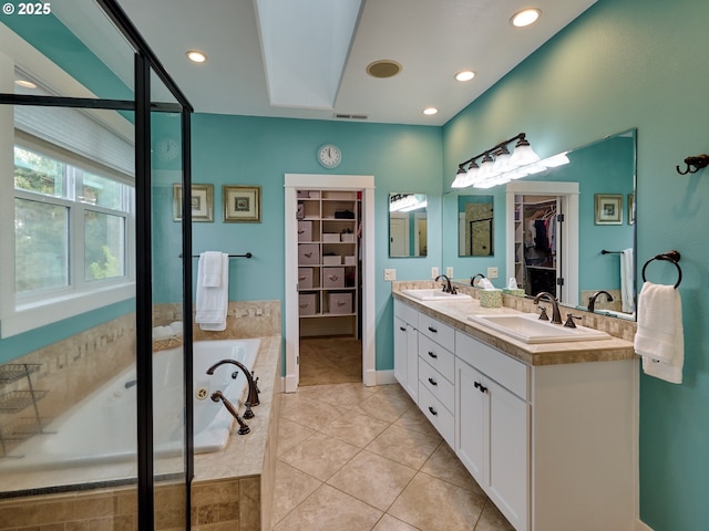 bathroom featuring visible vents, a sink, and a walk in closet