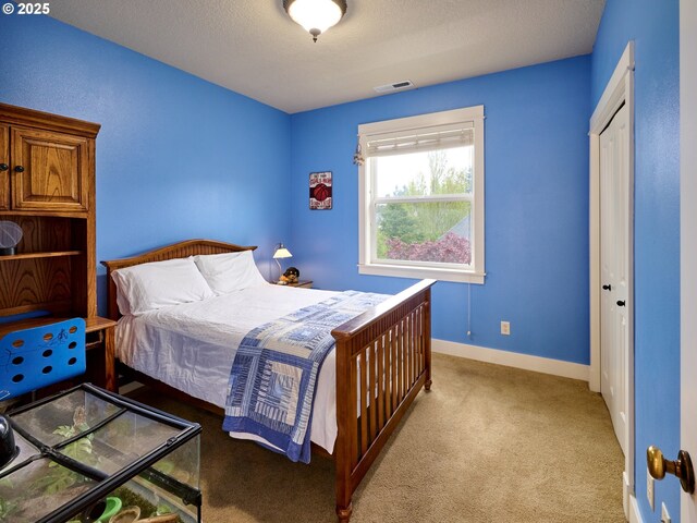 carpeted bedroom with baseboards, visible vents, and a textured ceiling