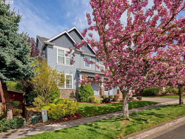view of front of house with a front lawn and stone siding