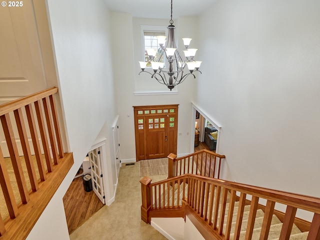 foyer entrance featuring a high ceiling, a chandelier, and stairway
