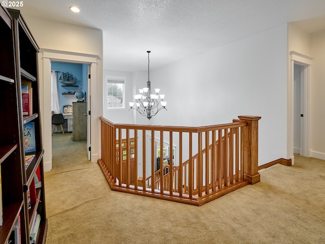 hallway with an upstairs landing, a notable chandelier, carpet floors, baseboards, and recessed lighting