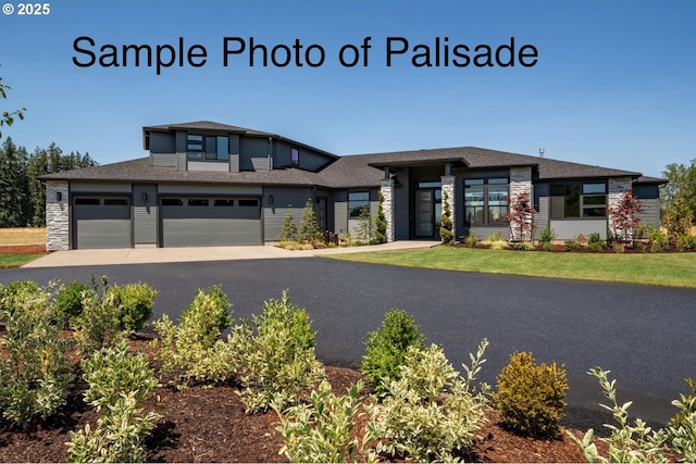 prairie-style home with driveway, stone siding, a shingled roof, and a garage