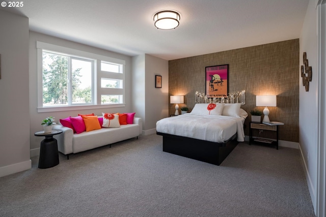 bedroom with an accent wall, carpet flooring, and baseboards