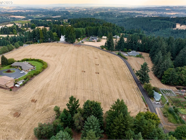 aerial view of property and surrounding area with a heavily wooded area and rural landscape