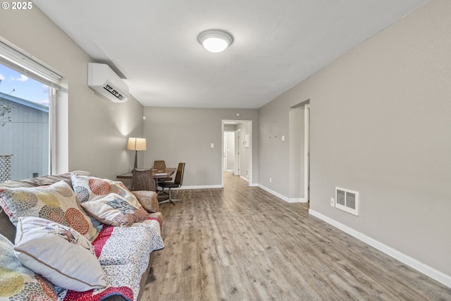 living room with light wood-type flooring and a wall mounted AC