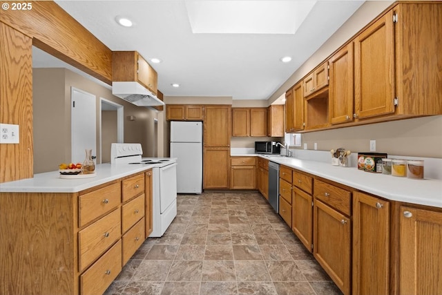 kitchen with white appliances, a skylight, brown cabinets, light countertops, and under cabinet range hood