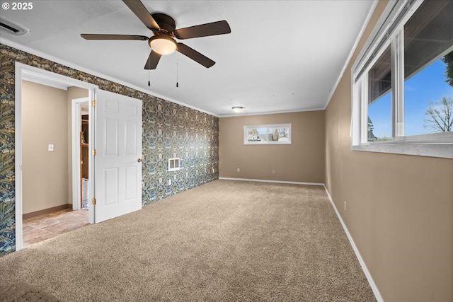 carpeted spare room with baseboards, visible vents, and ornamental molding