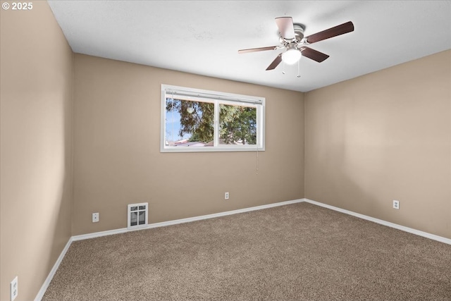 carpeted spare room with visible vents, baseboards, and ceiling fan