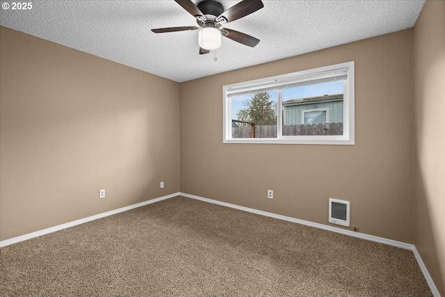 carpeted empty room with a ceiling fan, visible vents, a textured ceiling, and baseboards