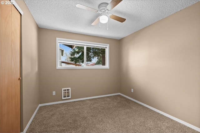 carpeted empty room featuring heating unit, a textured ceiling, baseboards, and a ceiling fan