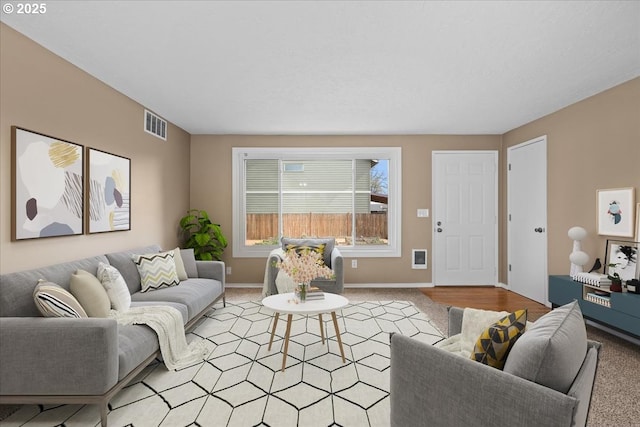 living area with light carpet, baseboards, and visible vents