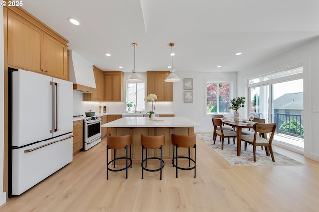 13212 SE Terra Cascade Dr, Happy Valley, OR 97086 - kitchen featuring range with electric stovetop, freestanding refrigerator, range hood, light countertops, and plenty of natural light