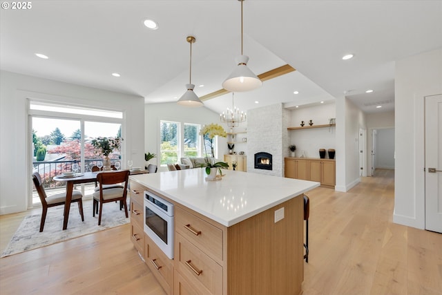 13212 SE Terra Cascade Dr, Happy Valley, OR 97086 - kitchen with built in microwave, light wood-type flooring, a kitchen island, lofted ceiling, and recessed lighting