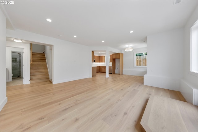 13212 SE Terra Cascade Dr, Happy Valley, OR 97086 - unfurnished living room with stairs, light wood-type flooring, recessed lighting, and baseboards