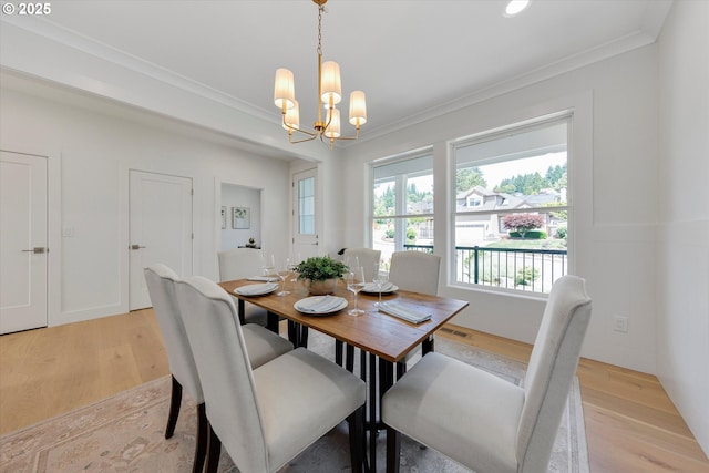 13212 SE Terra Cascade Dr, Happy Valley, OR 97086 - dining area with light wood-type flooring, a chandelier, and crown molding