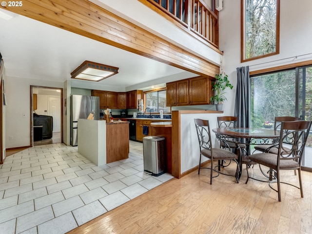 kitchen featuring brown cabinetry, light wood-style floors, a center island, and freestanding refrigerator