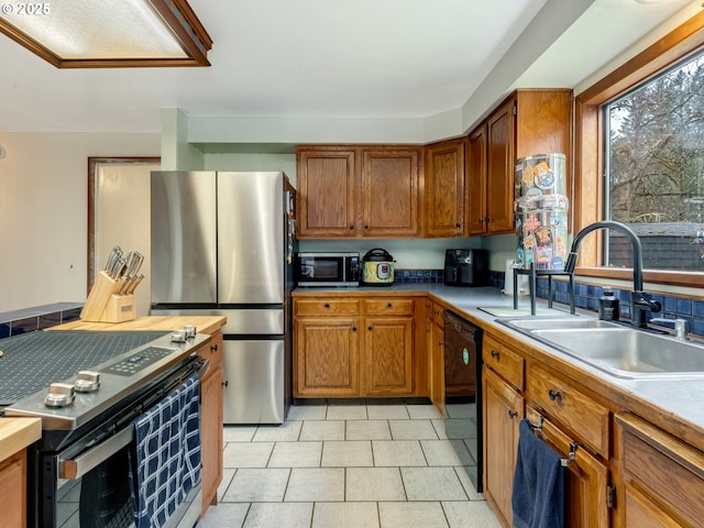 kitchen featuring brown cabinets, appliances with stainless steel finishes, and a sink