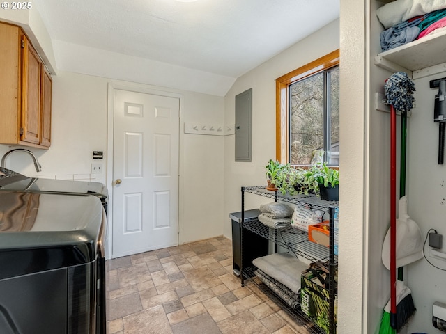 washroom with stone finish floor, electric panel, cabinet space, and independent washer and dryer