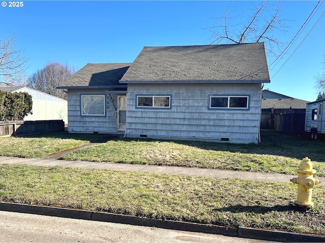 bungalow with a shingled roof, a front yard, crawl space, and fence