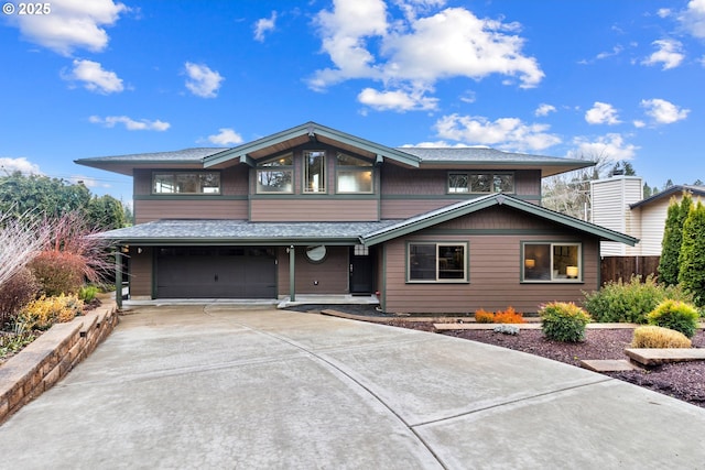 view of front of home featuring a shingled roof, driveway, an attached garage, and fence