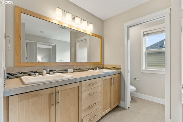 16185 NW Ashfield Dr, Beaverton, OR 97006 - full bath featuring double vanity, toilet, tile patterned floors, and backsplash