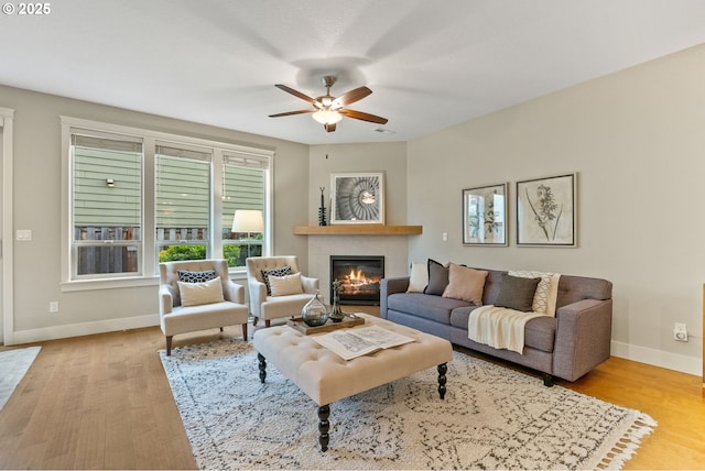 16185 NW Ashfield Dr, Beaverton, OR 97006 - living room featuring a glass covered fireplace, baseboards, healthy amount of natural light, and wood finished floors
