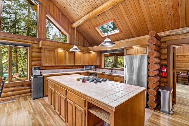 89935 Greenwood Dr, Leaburg, OR 97489 - kitchen with open shelves, log walls, tile counters, and a skylight