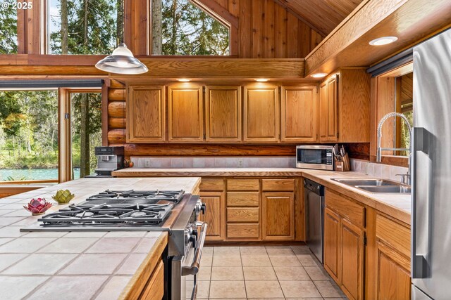 89935 Greenwood Dr, Leaburg, OR 97489 - kitchen featuring stainless steel appliances, tile countertops, light tile patterned floors, a sink, and high vaulted ceiling
