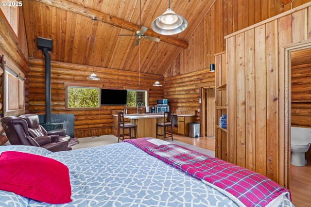 89935 Greenwood Dr, Leaburg, OR 97489 - bedroom featuring wood ceiling, wood finished floors, rustic walls, and a wood stove