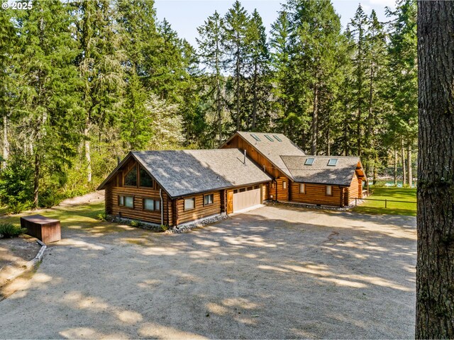 89935 Greenwood Dr, Leaburg, OR 97489 - view of side of home with roof with shingles, fence, log siding, an attached garage, and gravel driveway