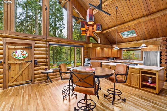 89935 Greenwood Dr, Leaburg, OR 97489 - dining area with rustic walls, a wealth of natural light, a skylight, and high vaulted ceiling