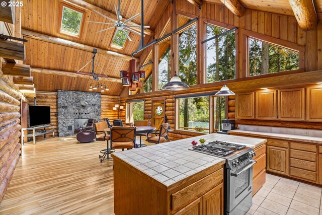 89935 Greenwood Dr, Leaburg, OR 97489 - kitchen featuring high vaulted ceiling, tile counters, wood ceiling, high end stainless steel range oven, and log walls