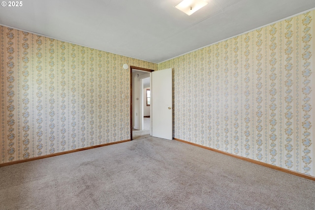 carpeted spare room featuring baseboards