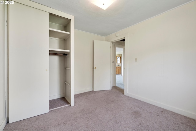 unfurnished bedroom featuring a closet, carpet, and baseboards