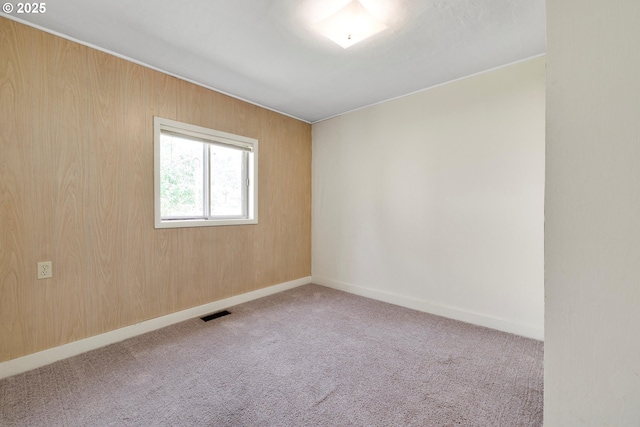 carpeted spare room featuring baseboards and visible vents